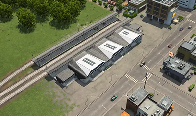 Rail station buildings, platforms, and tracks beside a town street